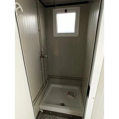 Unité sanitaire SDU avec toilettes, douche, lavabo et urinoir